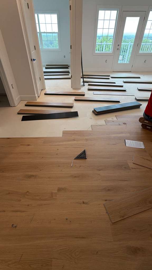 Partially installed flooring and prepared boards inside the Pine Brook condominium